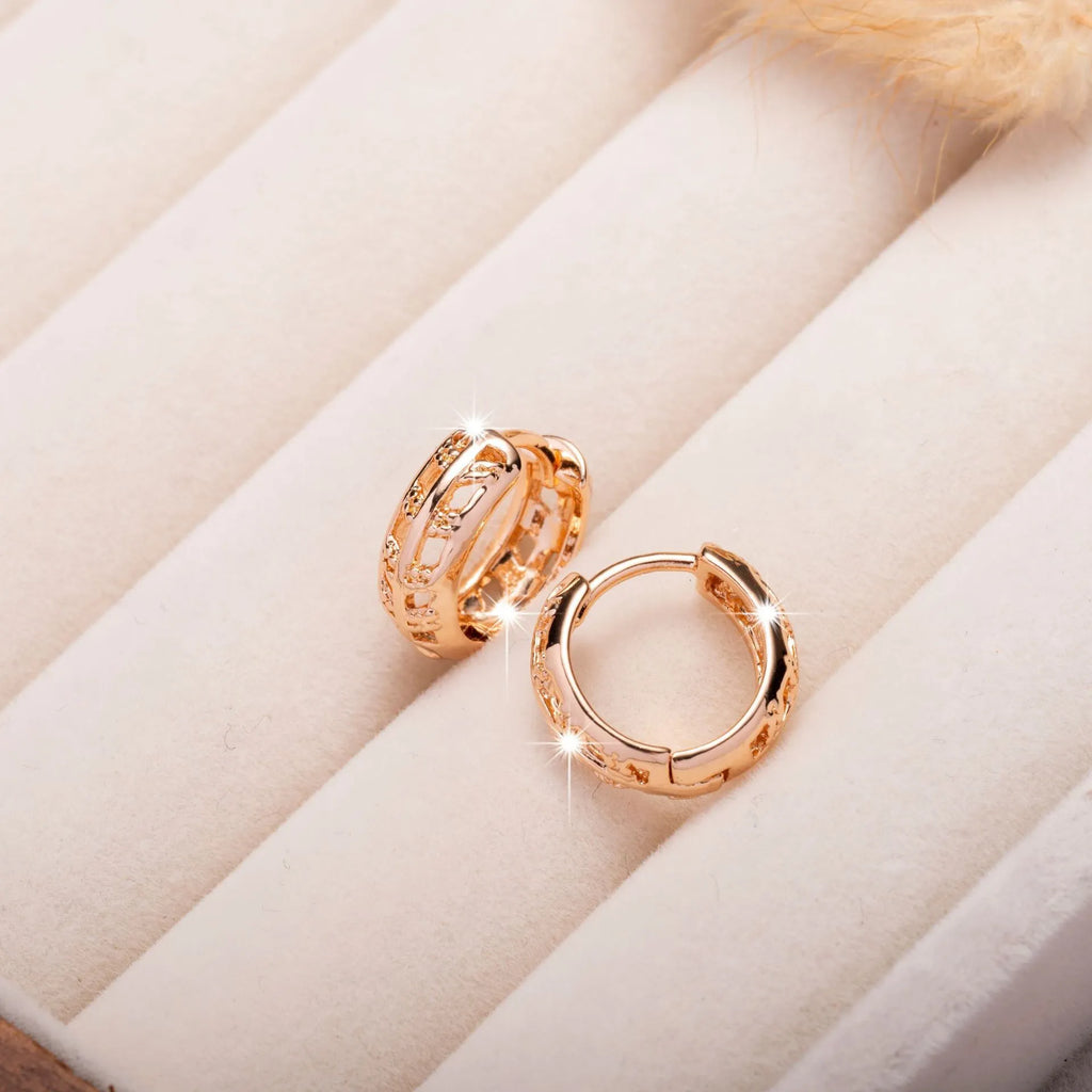 Hollowed-out copper earrings with leaf and heart designs in rose gold colour