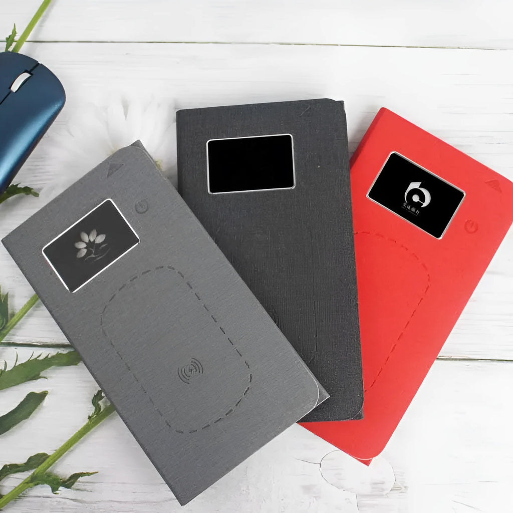 Folding cloth wireless charging mouse pad and small black wireless mouse shown with a portable handbag.