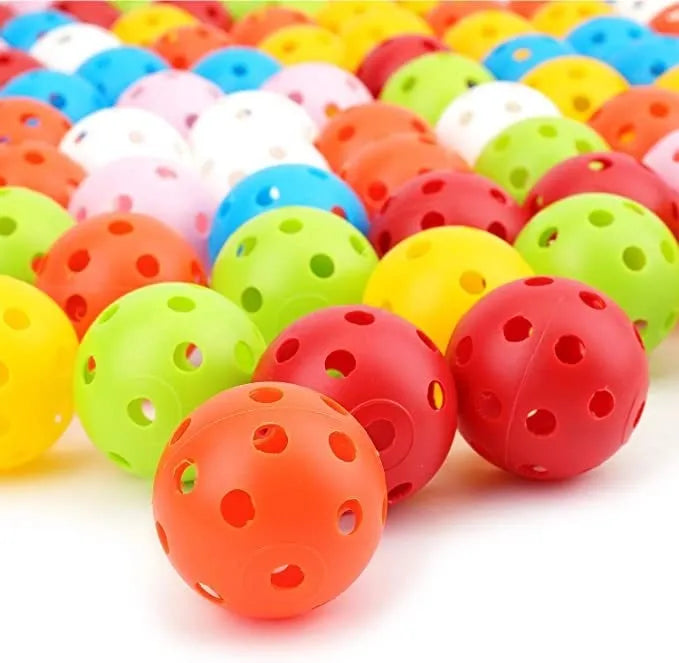 Multi-colour golf practice balls with 26-hole target design on green surface
