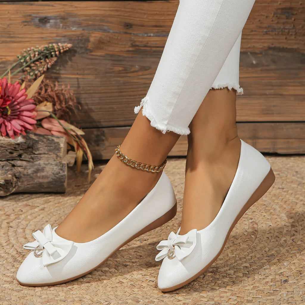Women's beige flat casual shoes with a bowknot and shallow mouth design on a white background.