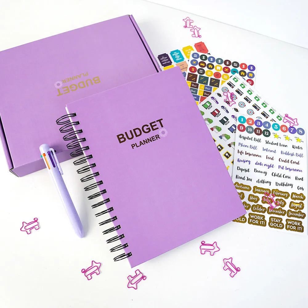 Purple coil-bound budget book with stickers and paper clips for monthly financial planning