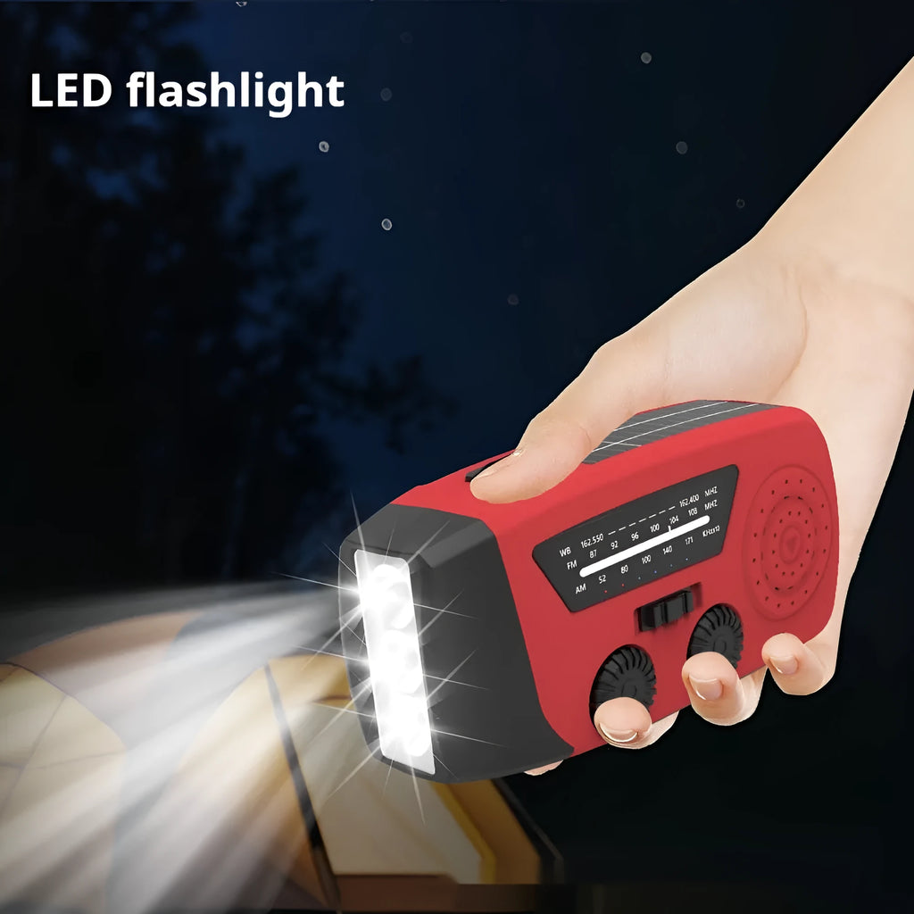 Red rechargeable hand-held radio with emergency torch, USB port, speaker, and wrist strap.