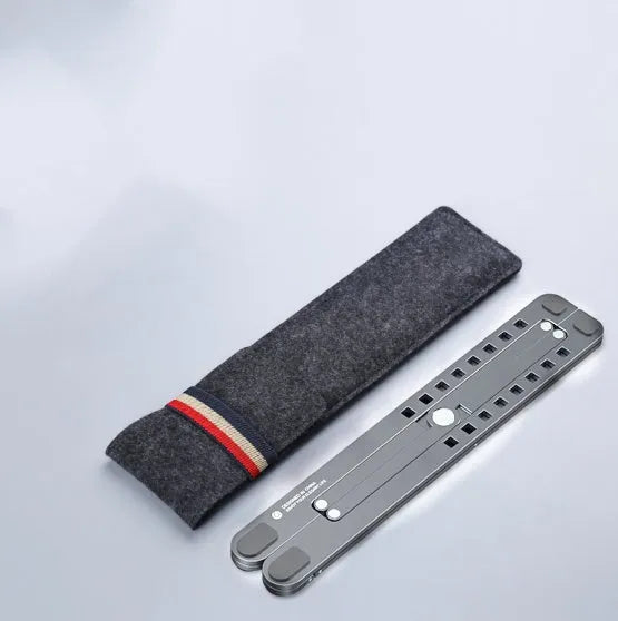 Foldable aluminium laptop stand in silver, shown supporting a laptop at an angle.