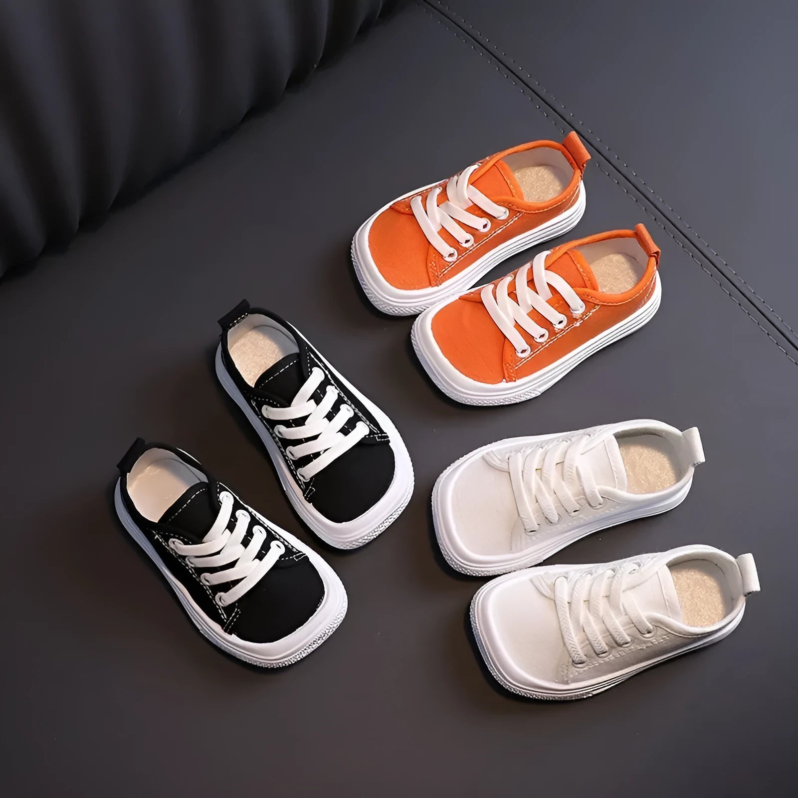Children's canvas shoes low top sneakers in orange black white leopard print and plaid on a white background