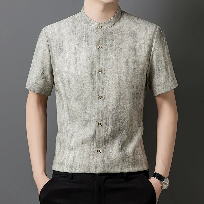 Man wearing a loose grey short sleeve cardigan shirt with a stand collar.