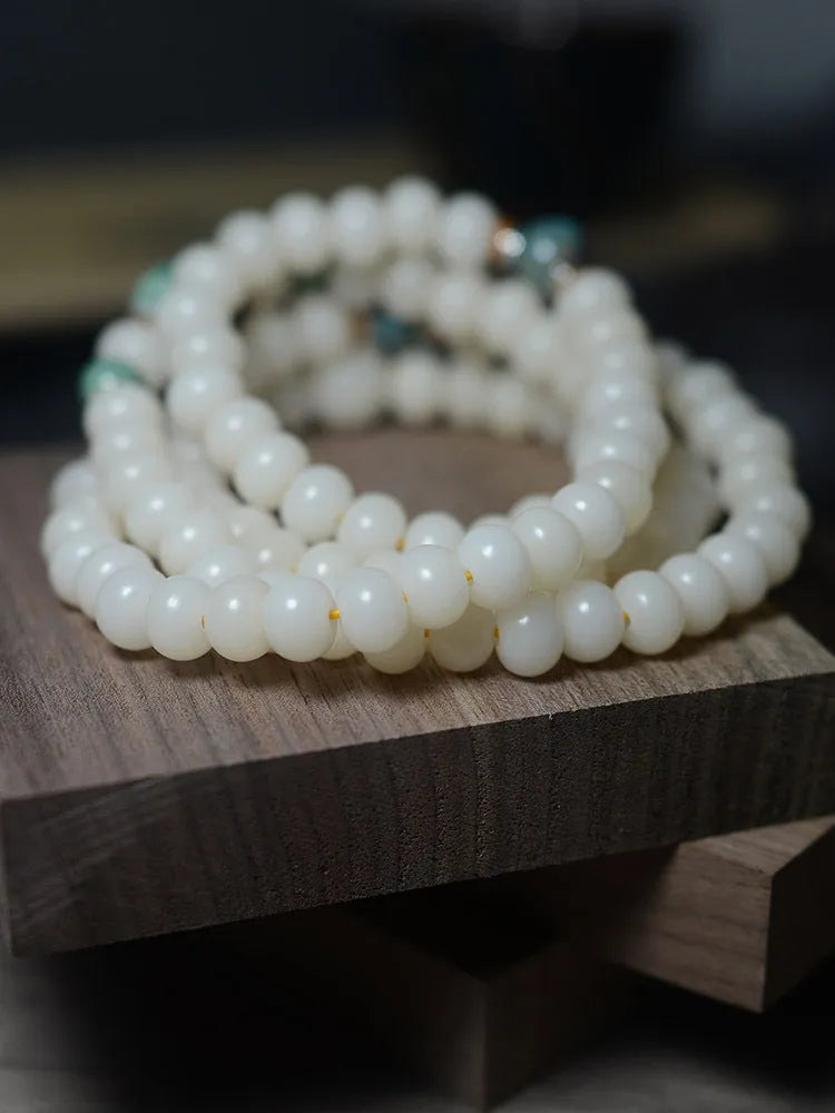 White jade bodhi seed bracelet with 108 flat round beads in two sizes on wrist