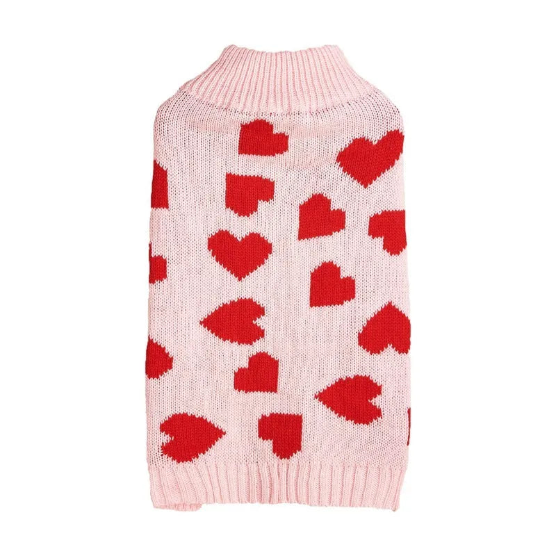 Red knitted dog jumper with a white love heart and bow design on a small dog
