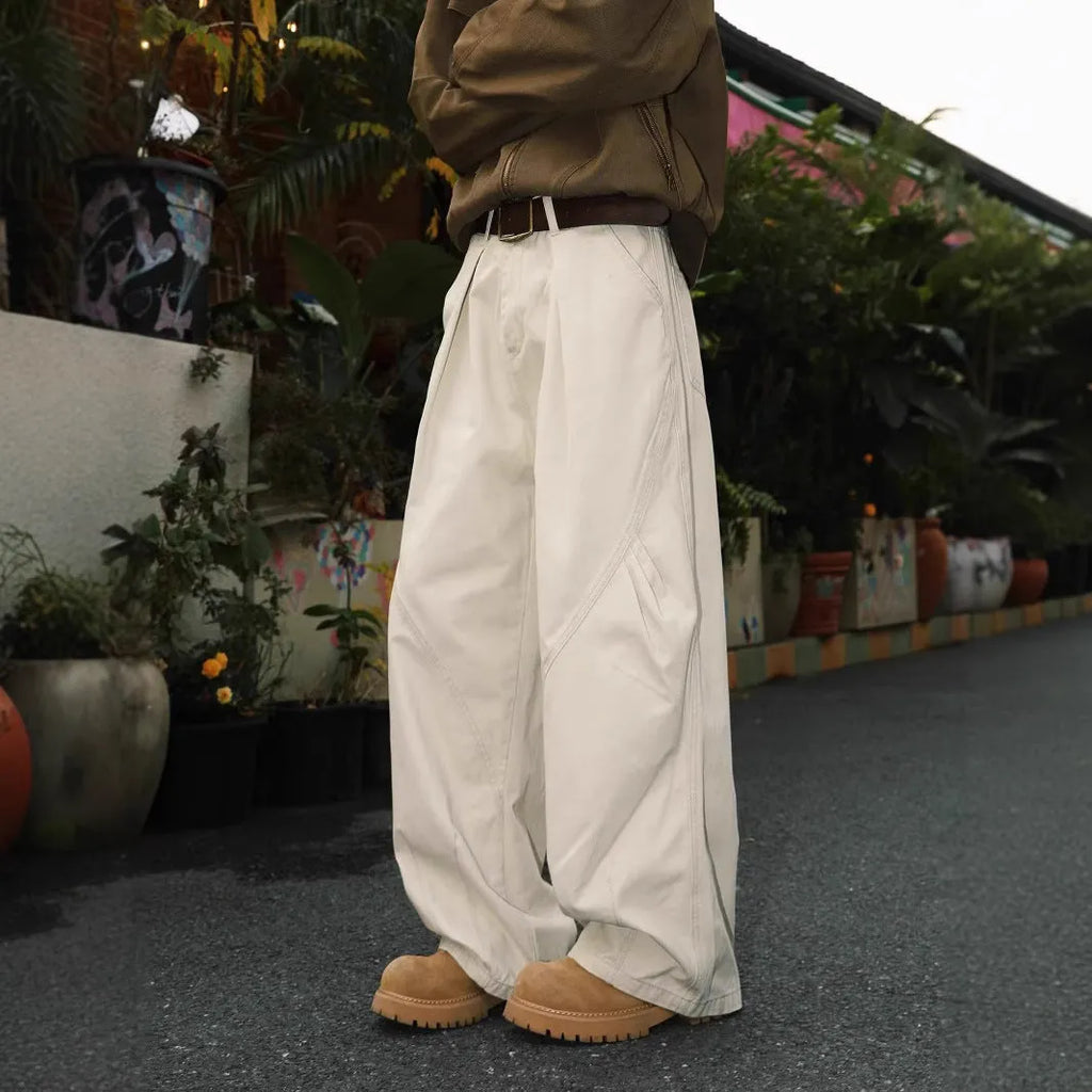 Men's pleated straight-leg loose trousers in apricot colour showing front detail and micro-elastic waistband.