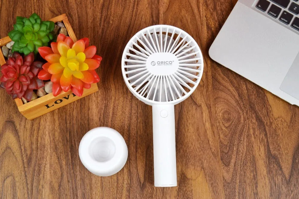 White ORICO FH1 USB rechargeable desk fan with fine-line texture on a desk, showing compact size.