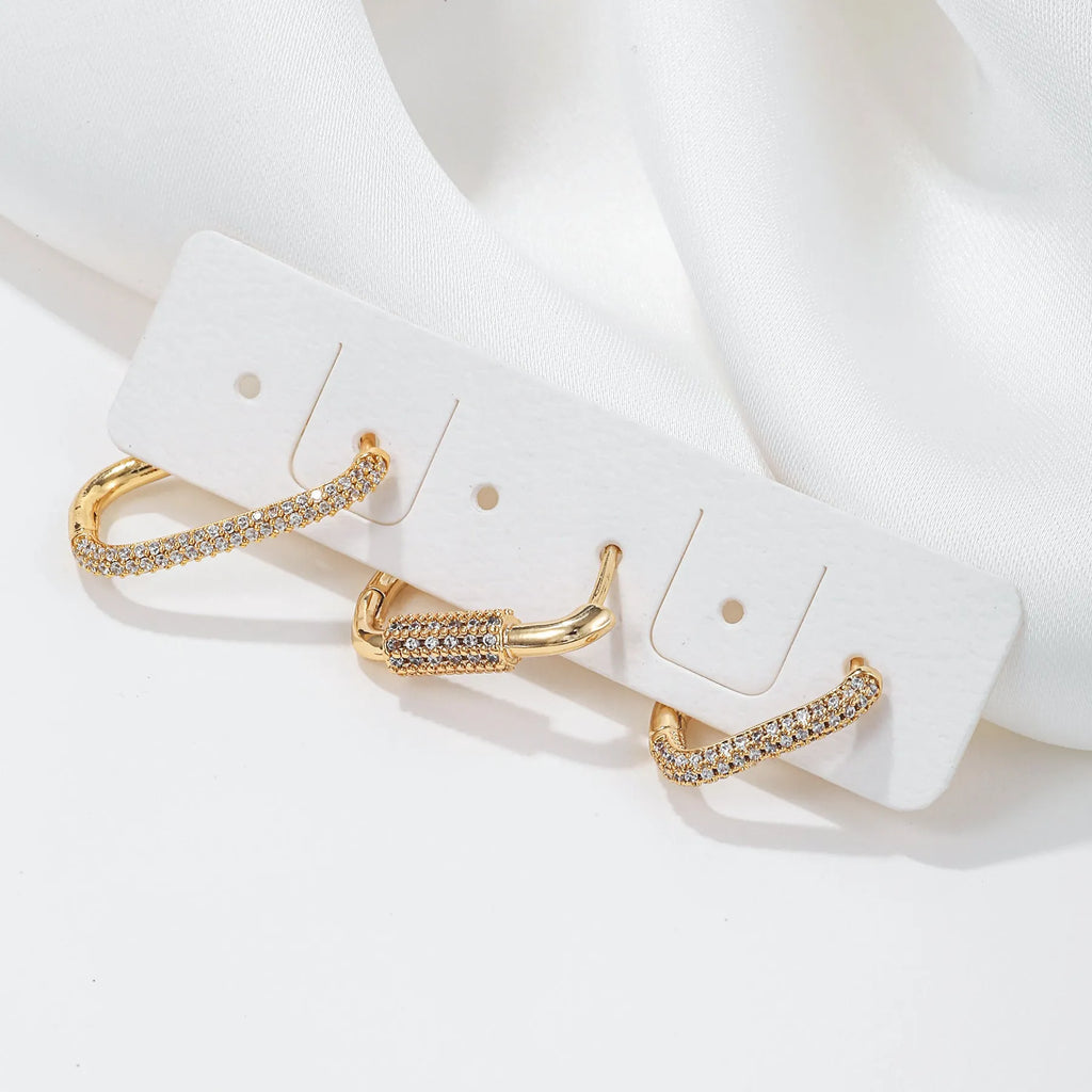 Three geometric copper ear clips with micro inlaid zircon stones in gold and white gold finishes