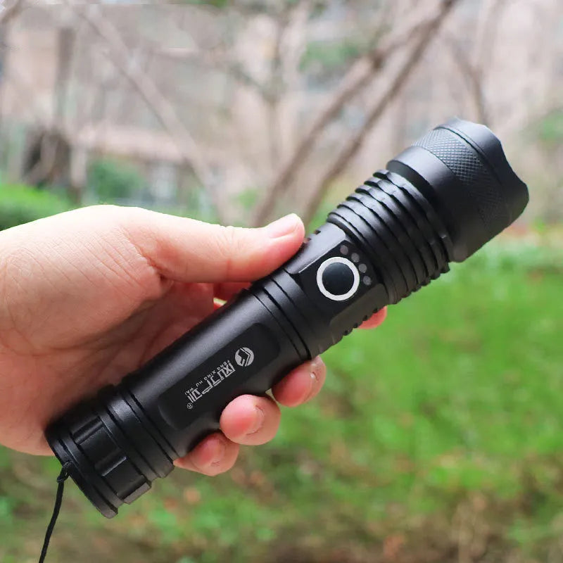 Black aluminium alloy rechargeable LED flashlight with zoom lens on grey background