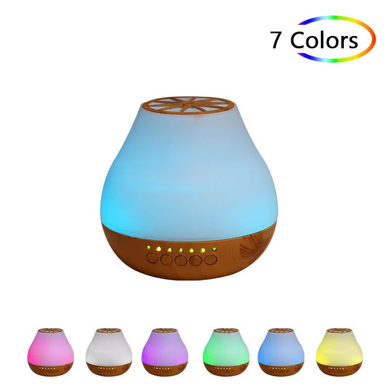 Wood grain finish USB aroma diffuser on a table next to a bottle of essential oil.