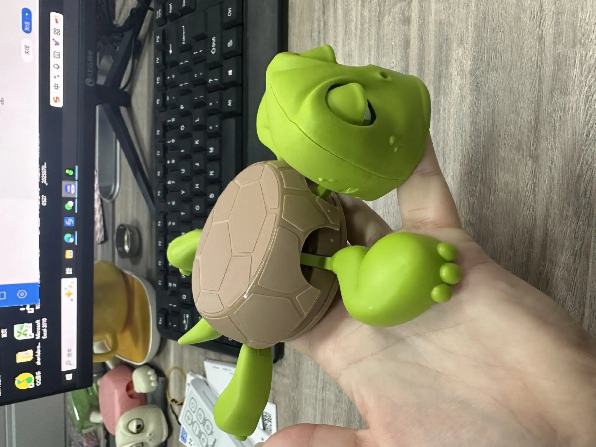 Turtle-shaped ABS plastic coaster in light green on a wooden table
