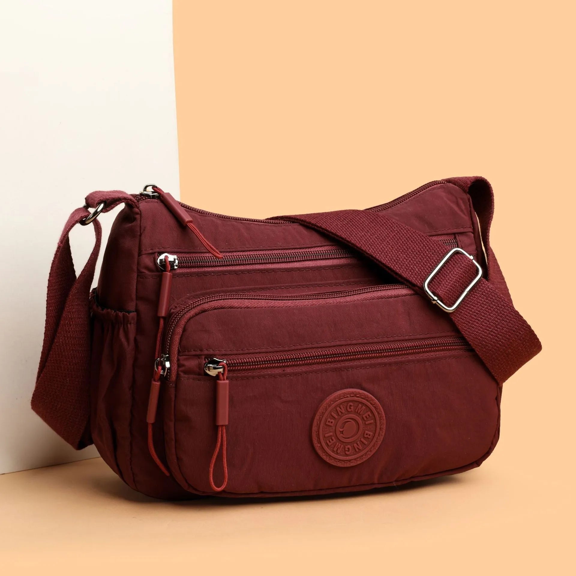 Water-repellent nylon crossbody cloth bag showing internal zipper compartments and shoulder strap