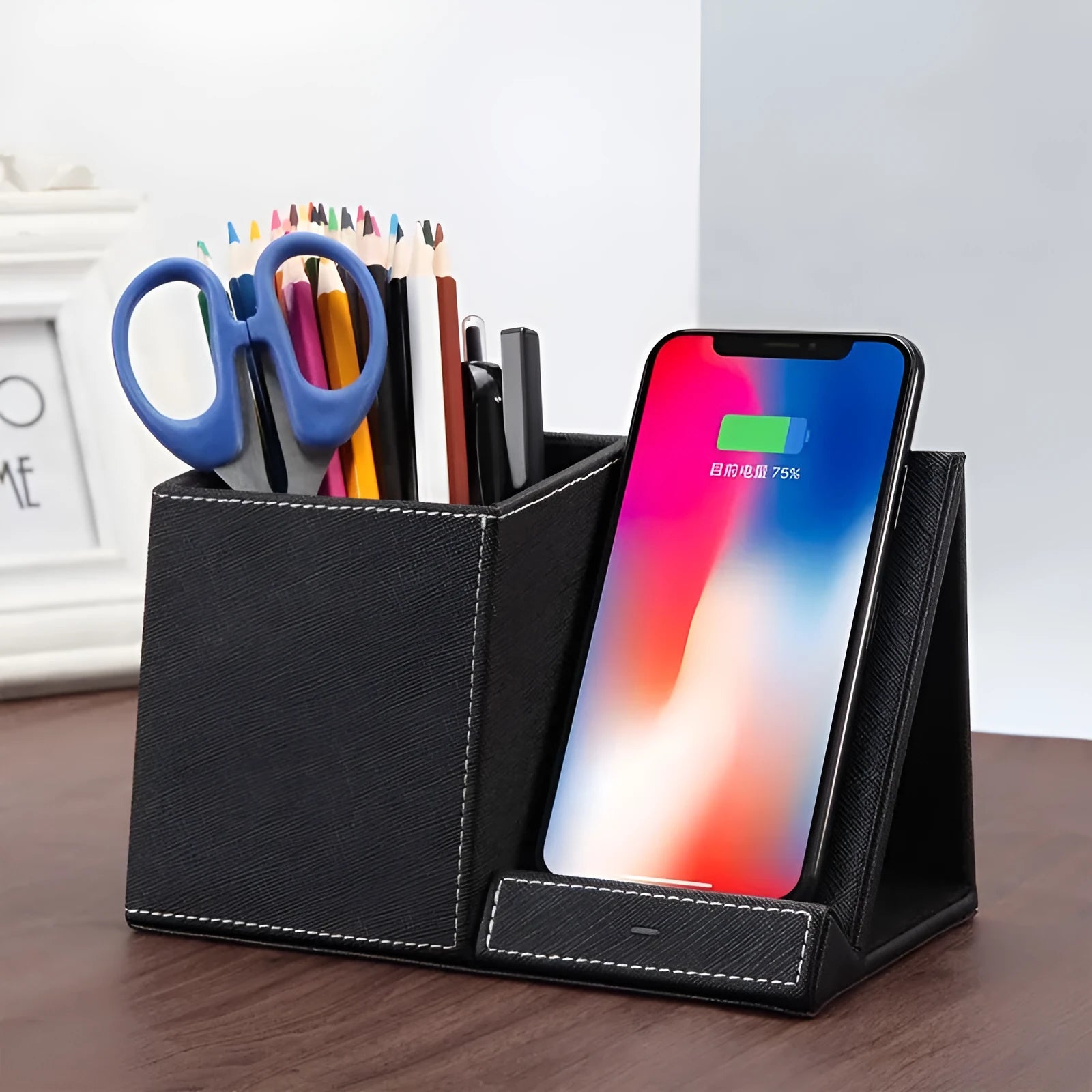 Black leather wireless charging station with phone on stand and pens in holder