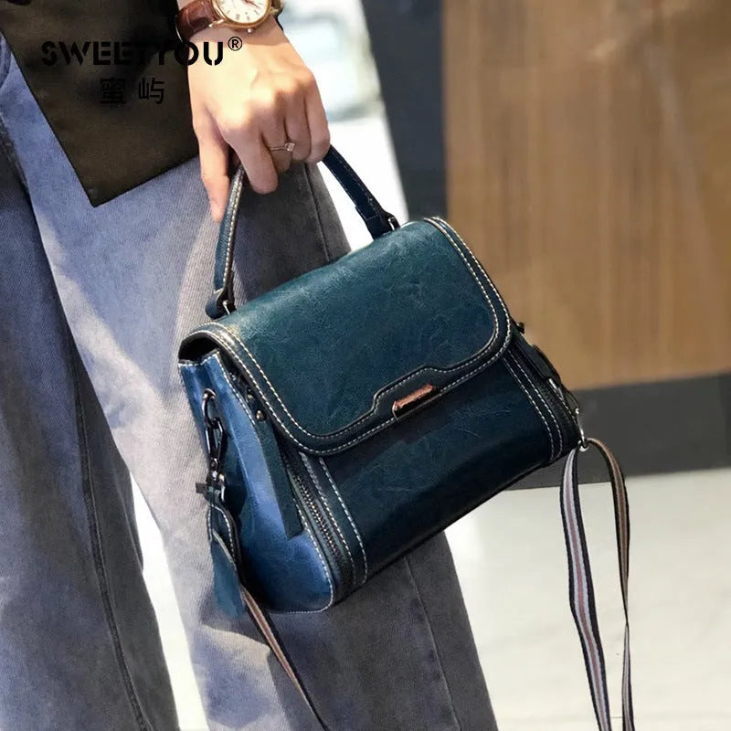 Women's brown genuine leather retro messenger bag with double strap and external pockets.
