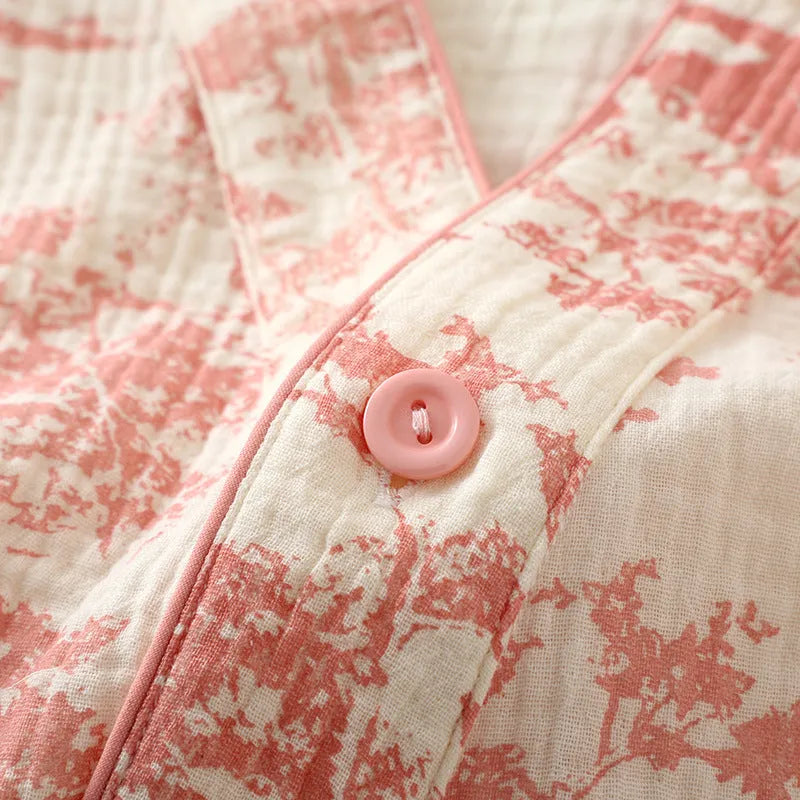 Women's pink cotton gauze lounge suit set with lace-up long sleeve top and matching trousers on a hanger.
