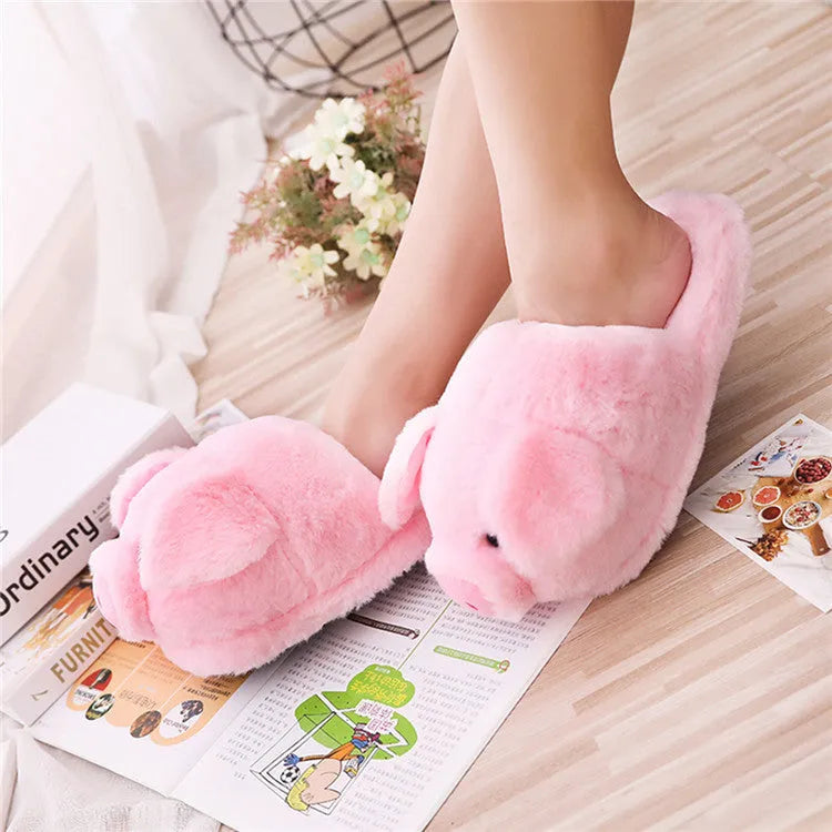 Pink plush pig face design floor slippers on a white background.