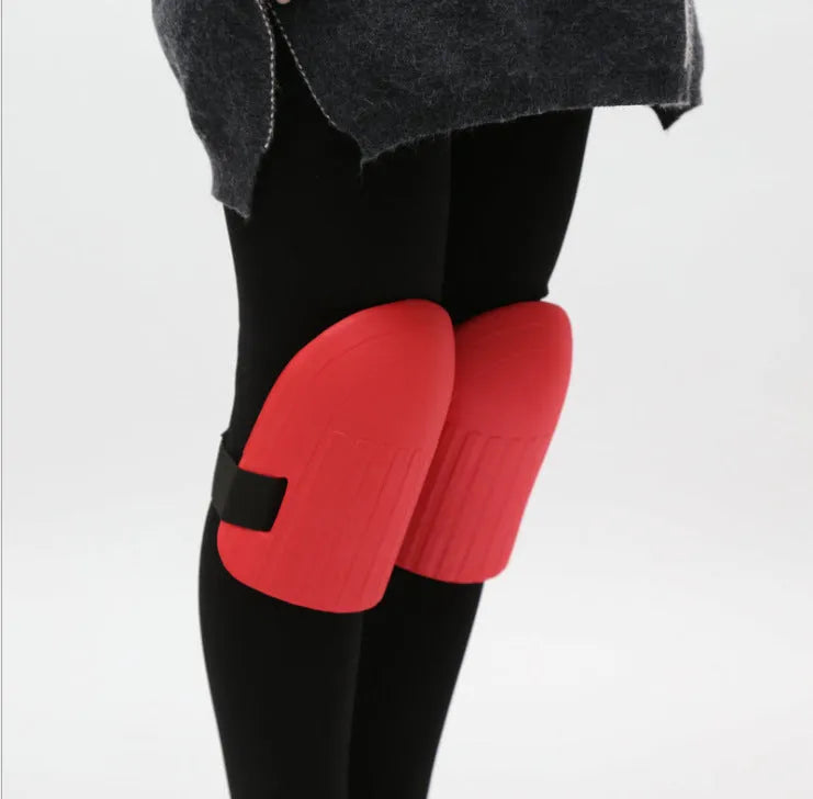 A pair of thick EVA foam knee pads in army green colour, shown on a wooden surface.