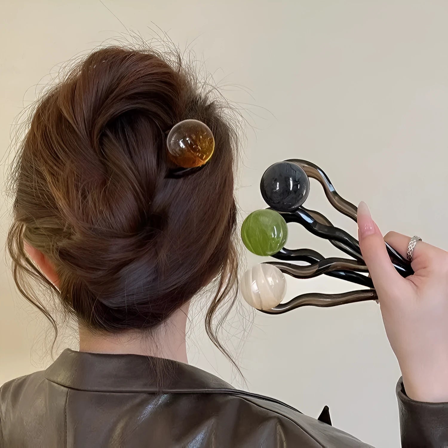 Acrylic U-shaped hair barrette with a small spherical decoration in a beige and caramel two-tone colour combination.