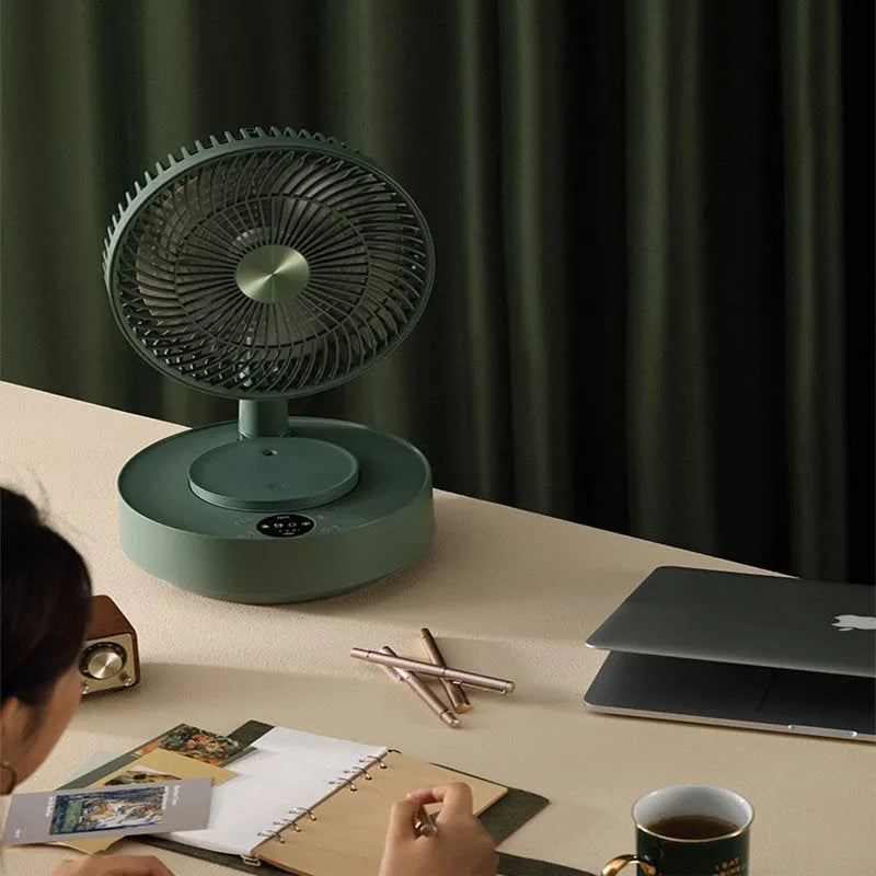 Green telescopic floor fan extended to full height with remote control resting beside base