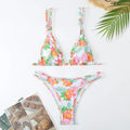 Women's floral print halter top and bikini briefs set for swimming on a blue background.