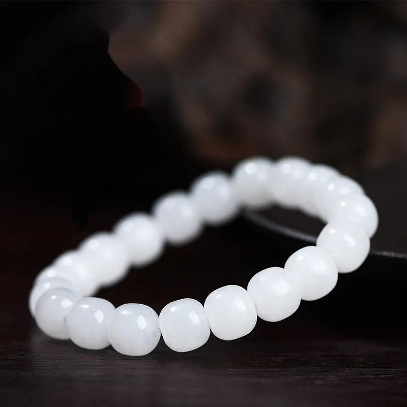 White Hetian jade barrel bead bracelet on wrist, showing unisex design and elasticated band.