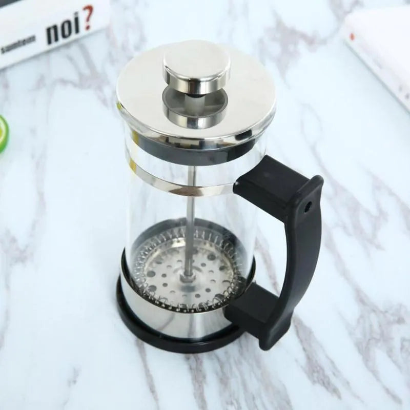 Compact pour-over coffee maker with glass carafe and stainless steel filter holder