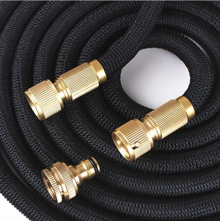 Expandable magic flexible water hose in black laid on grass showing compact initial length and stretched working length