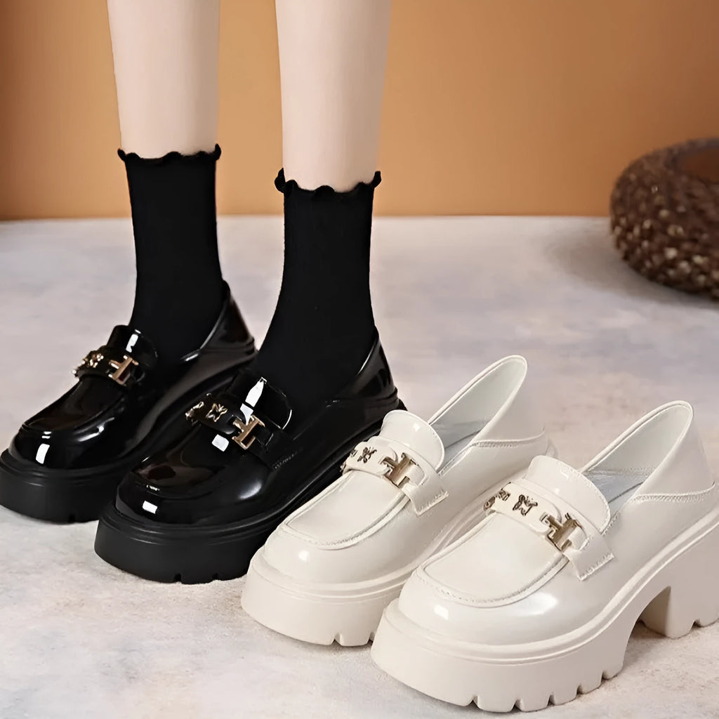 Slip-on chunky heel black leather shoes with skull pattern and square heel on a white background