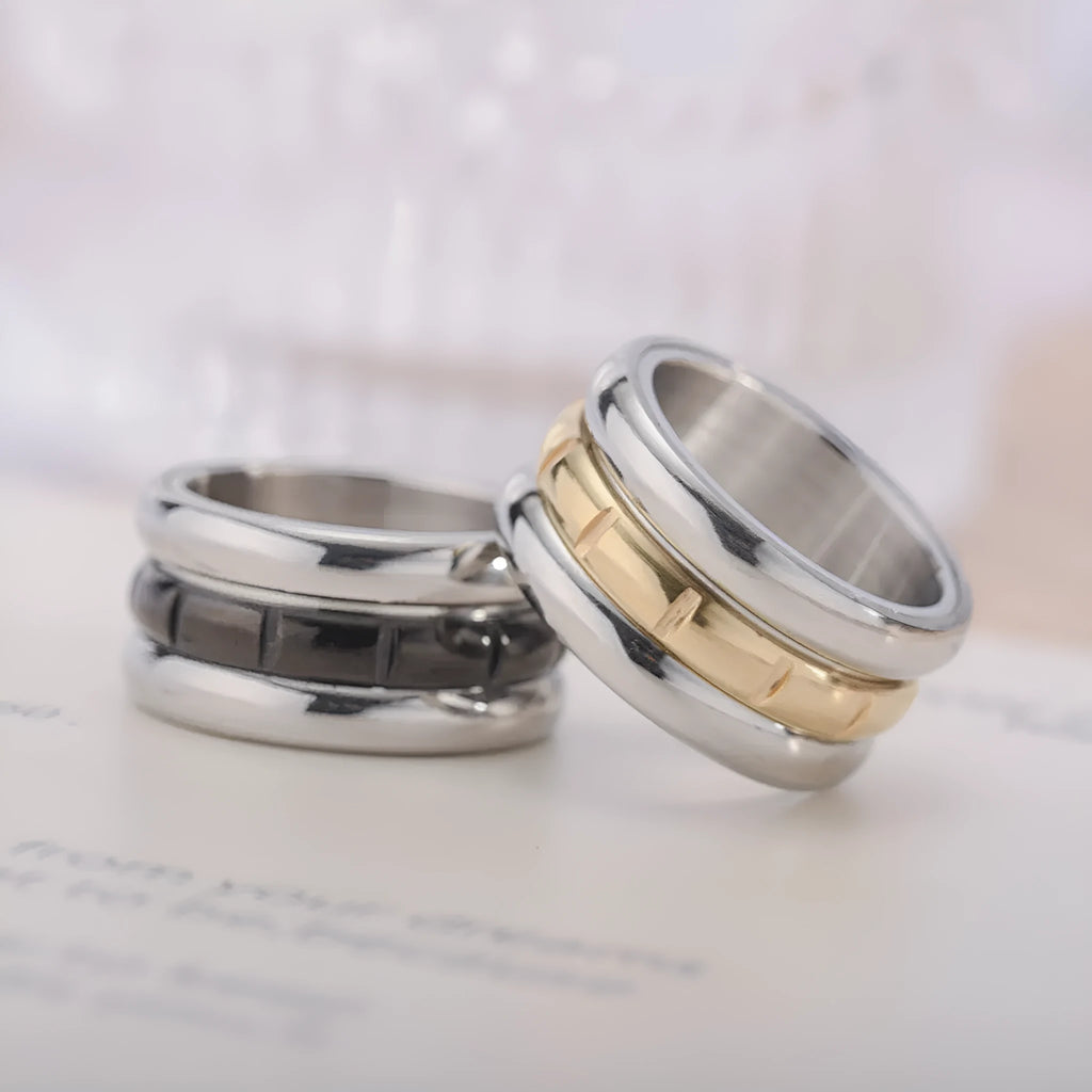 Titanium steel rotating ring with carved geometric band, shown in black or gold, unisex sizes 6 to 13
