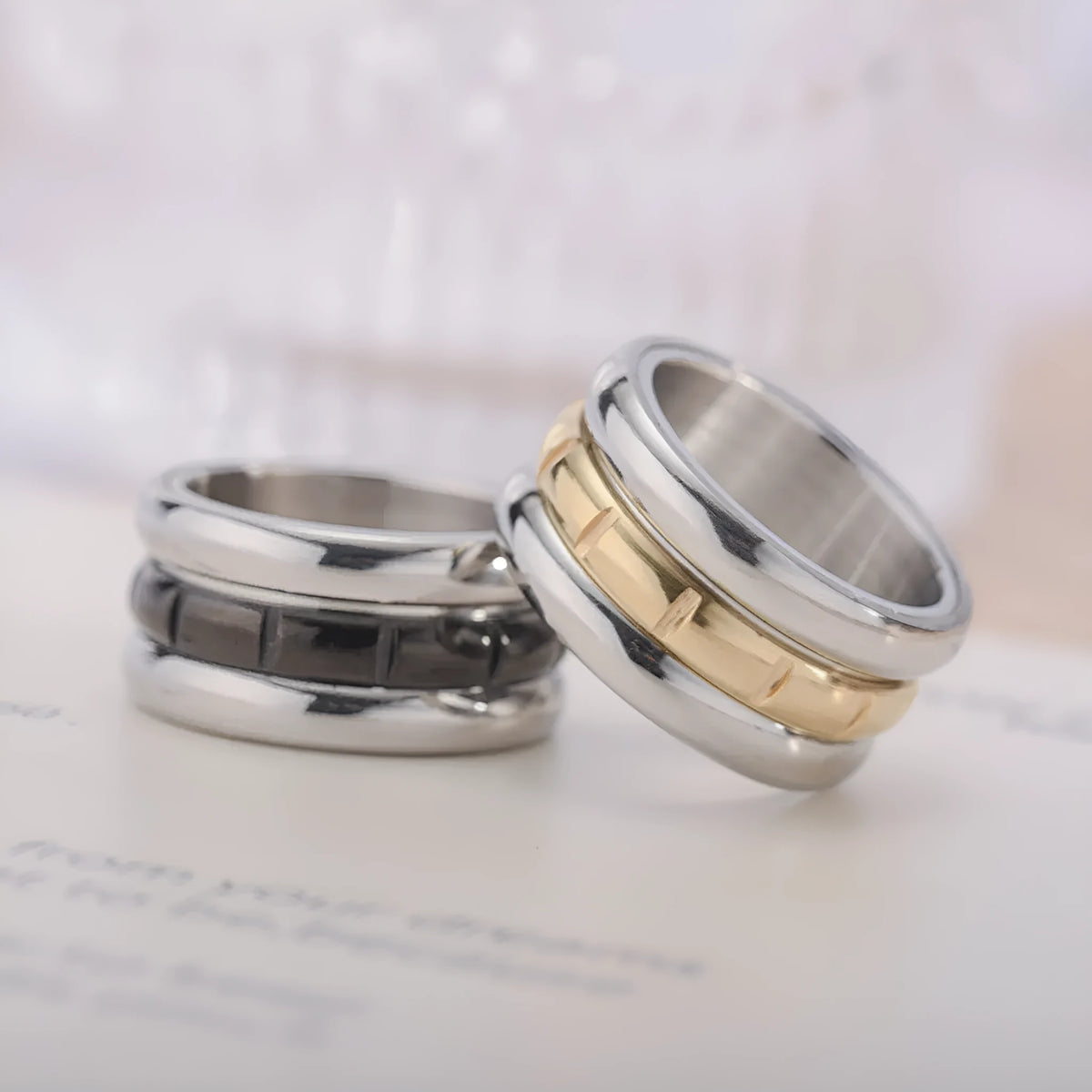 Titanium steel rotating ring with carved geometric band, shown in black or gold, unisex sizes 6 to 13