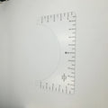 Transparent acrylic sewing ruler for aligning T-shirt designs, measuring 10 by 6 inches.