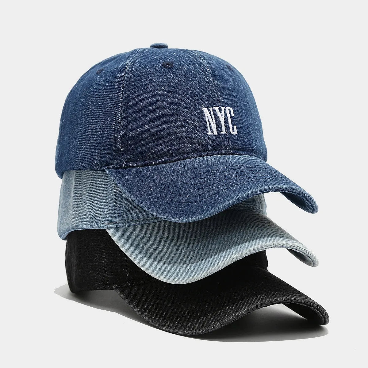 Light blue denim baseball cap with dome crown and printed alphabet letters on the front.