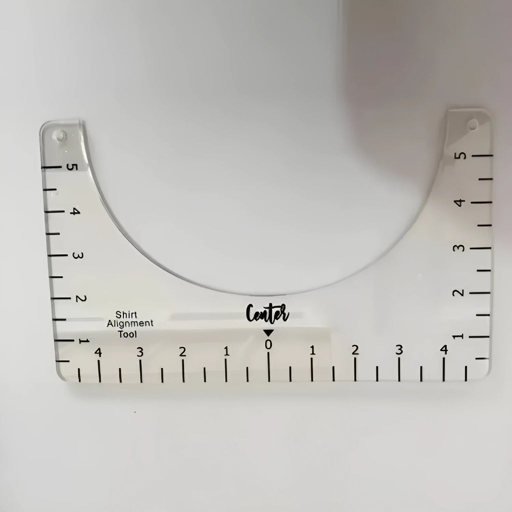 Transparent acrylic sewing ruler for aligning T-shirt designs, measuring 10 by 6 inches.