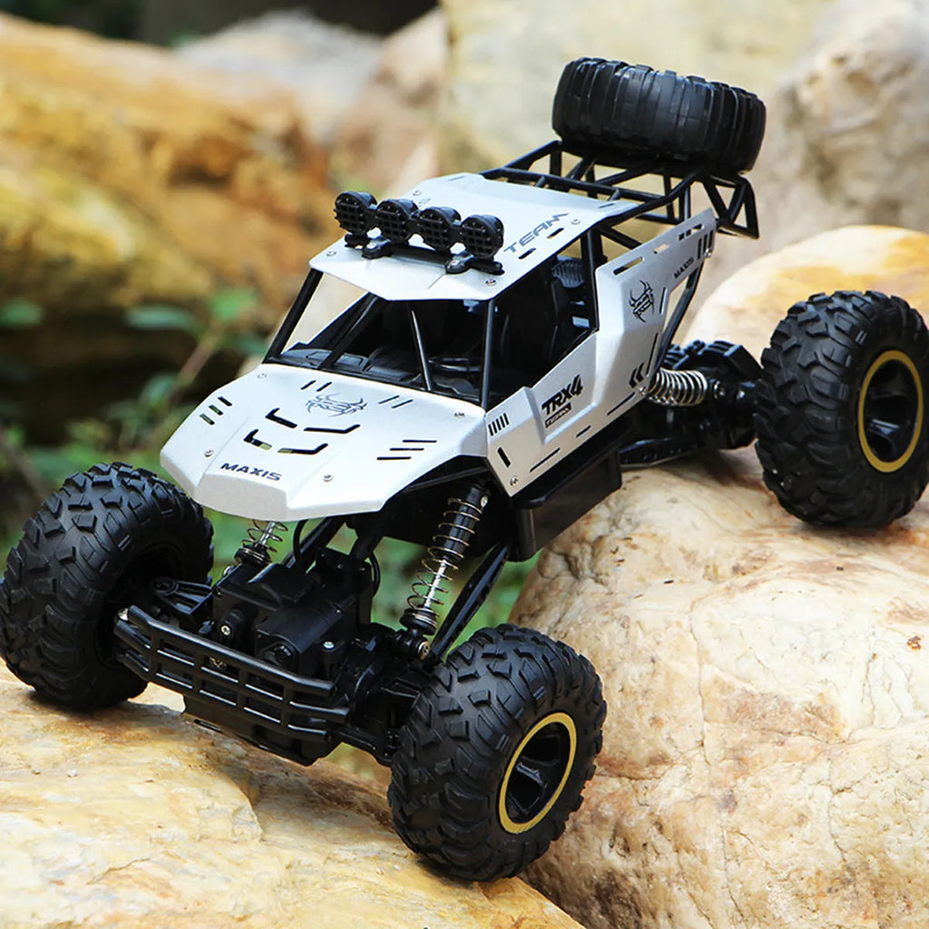 Large black 4WD remote control off-road climbing car on a rocky surface.