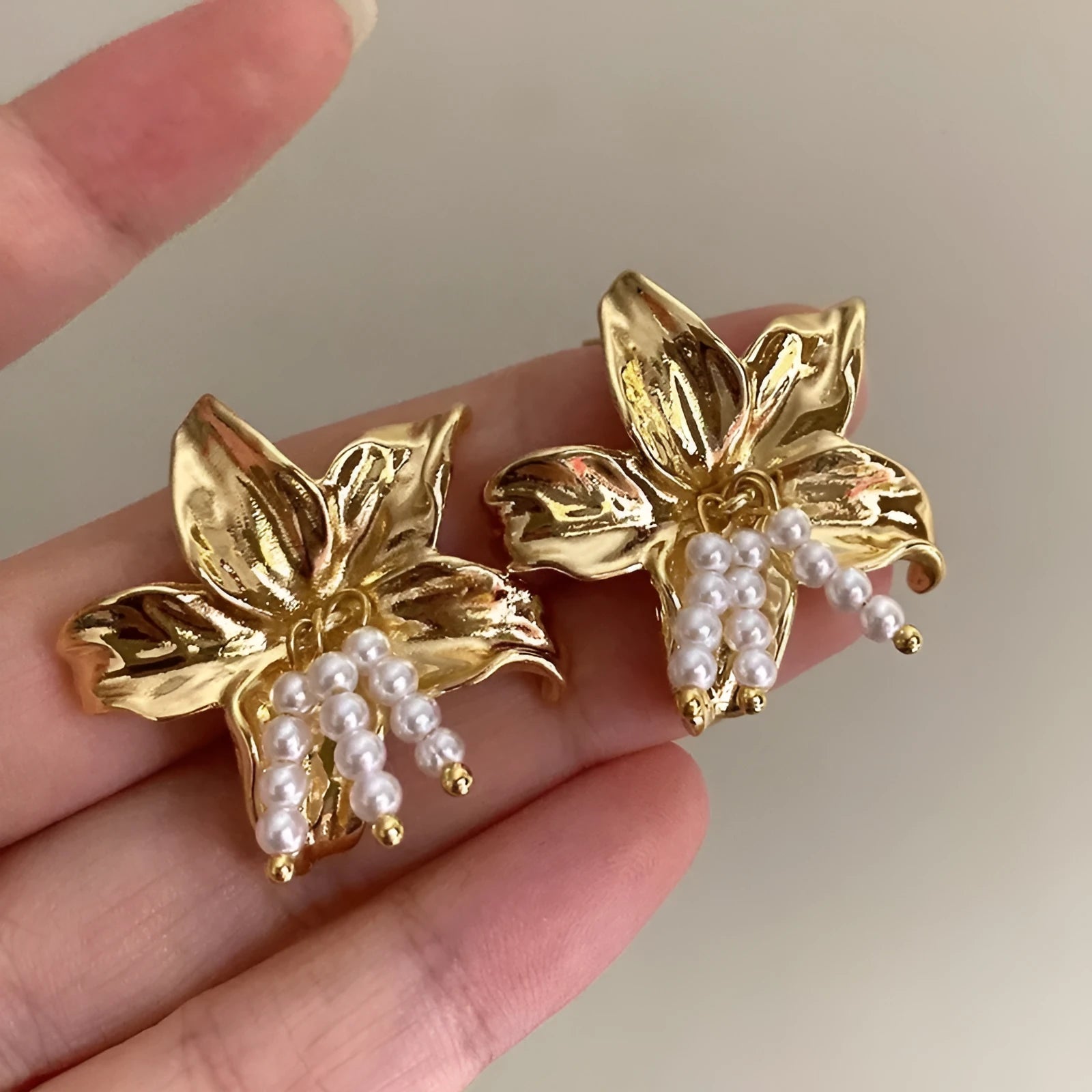 Exaggerated gold H1795 pearl flower earrings with Seiko crystal treatment, showing floral design.