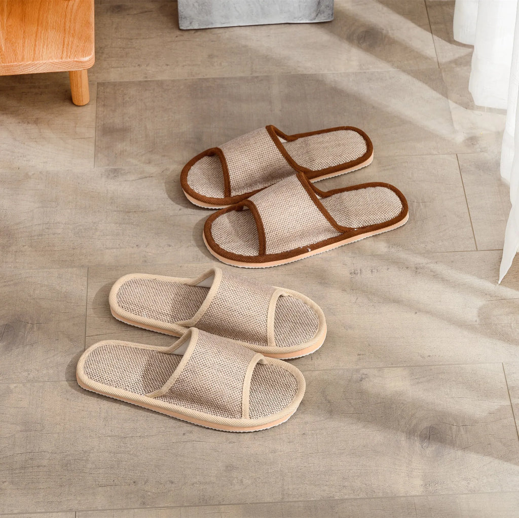 Women's open-toe linen slippers in light brown on a wooden floor, showing the breathable design and thickened sole.