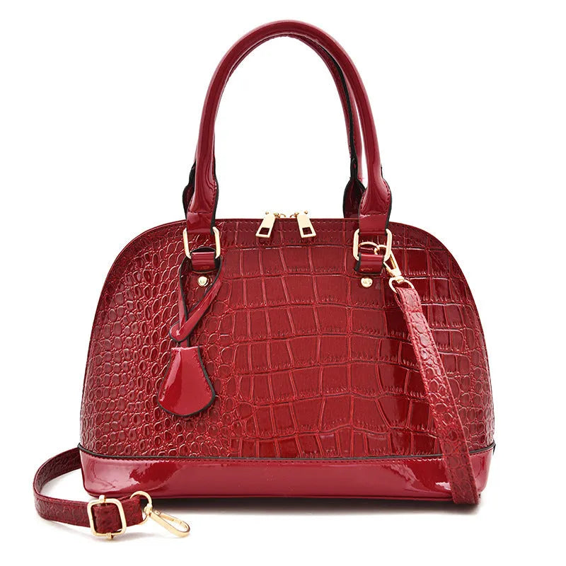 Large shiny black PU leather crossbody bag with structured shell shape design.
