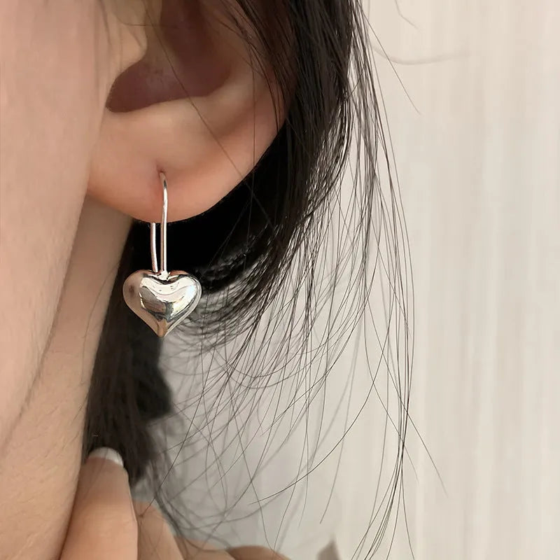 Silver-coloured heart-shaped earrings with three-dimensional glossy finish and Korean-style design