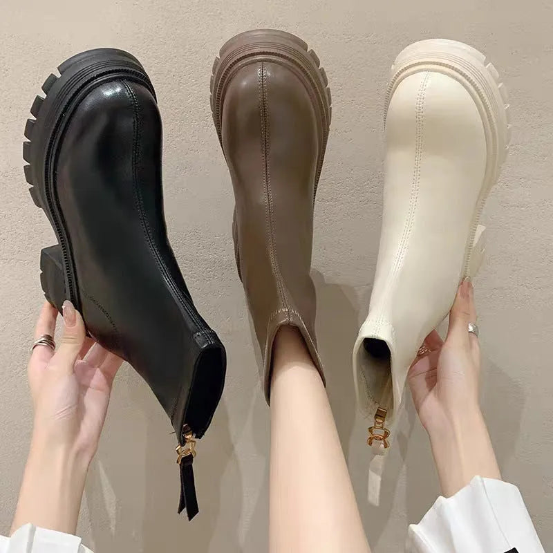 White platform ankle boots for women with thick foam rubber sole, mid-calf shaft, square heel, round toe, and back zipper.