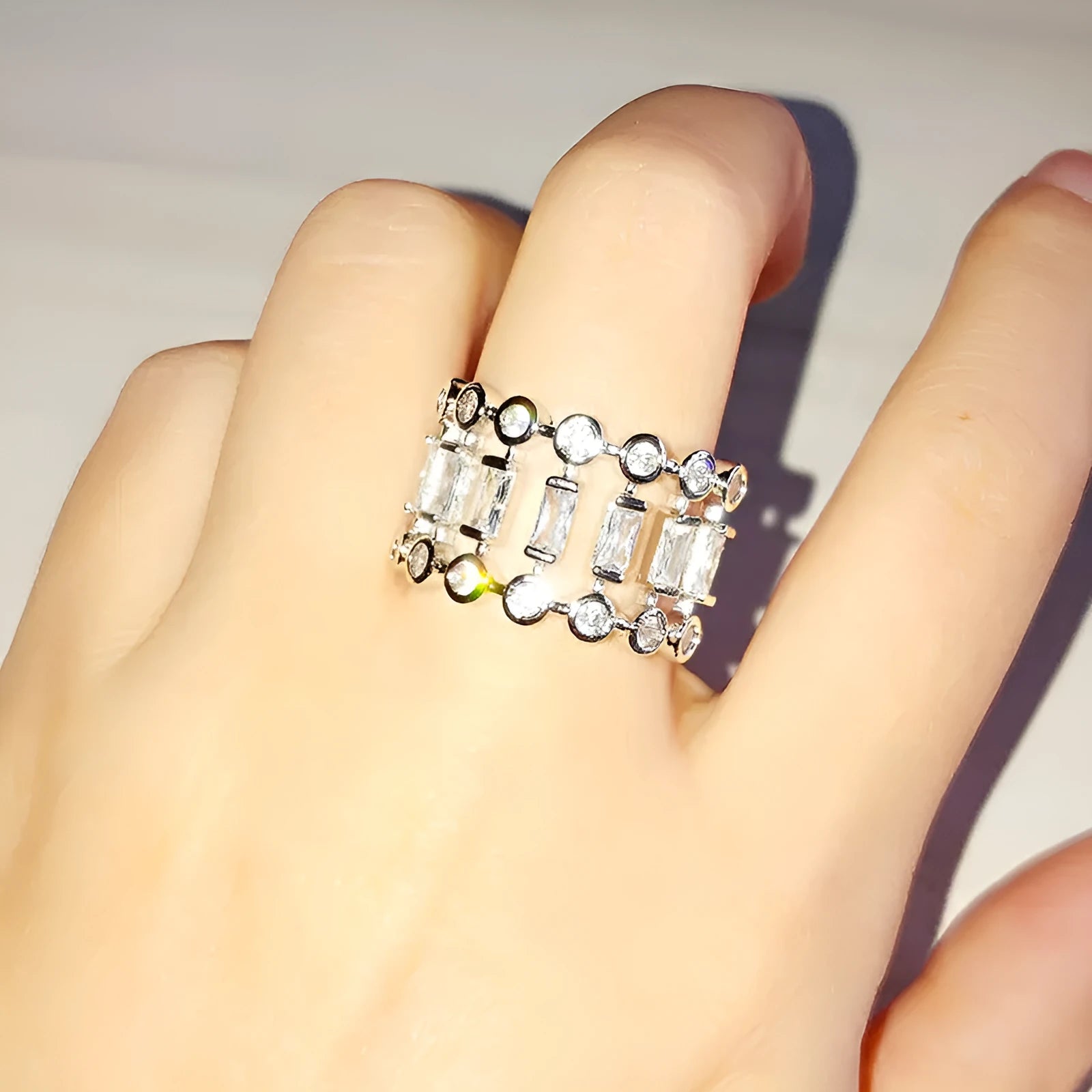 Gold-plated copper ring with hollow geometric setting and inlaid zircon stones