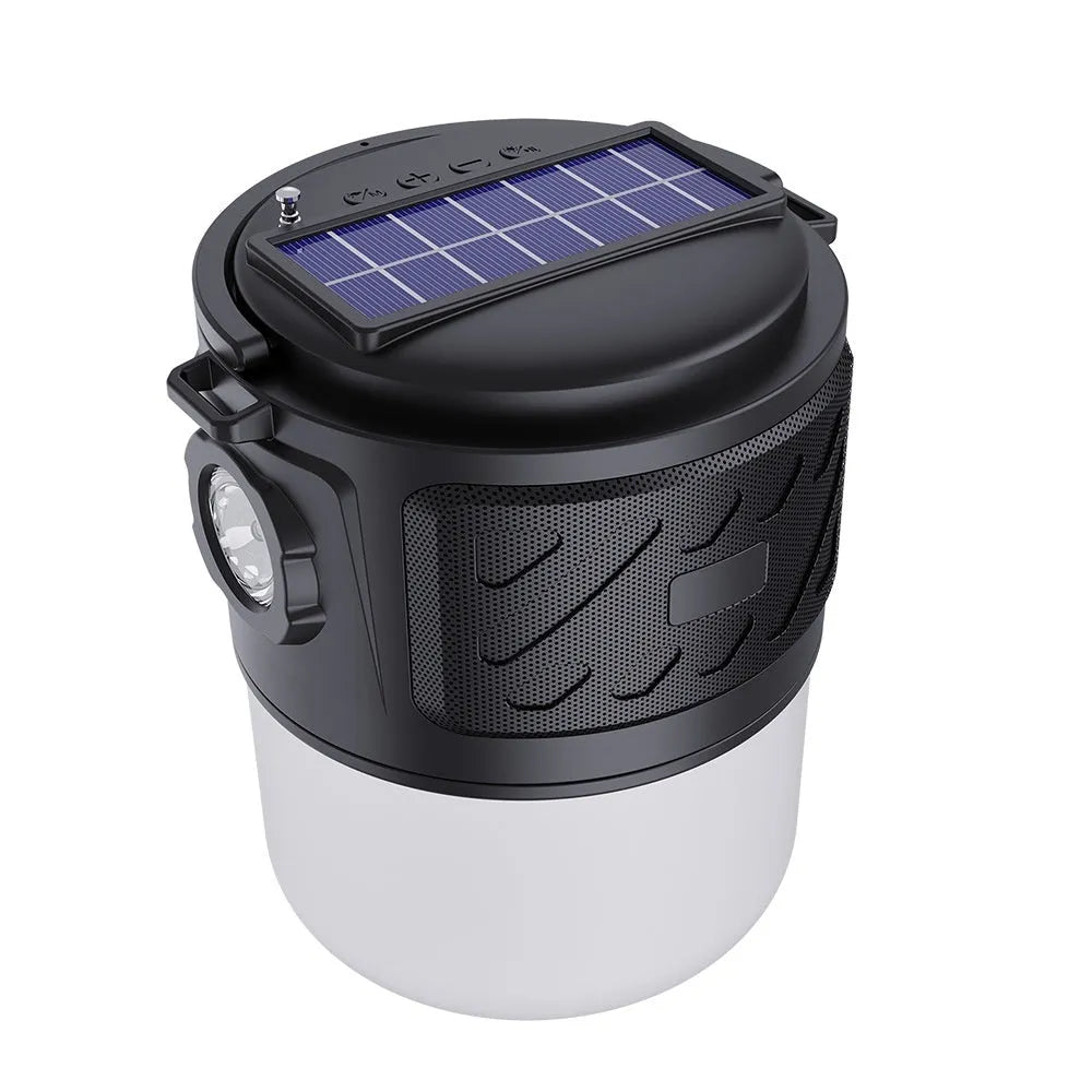 Portable solar camping lantern speaker with Bluetooth, LED light, USB rechargeable, black colour, on outdoor lawn