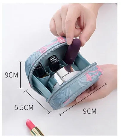Blue cloth cube-shaped makeup bag with a zipper closure, resting on a surface.