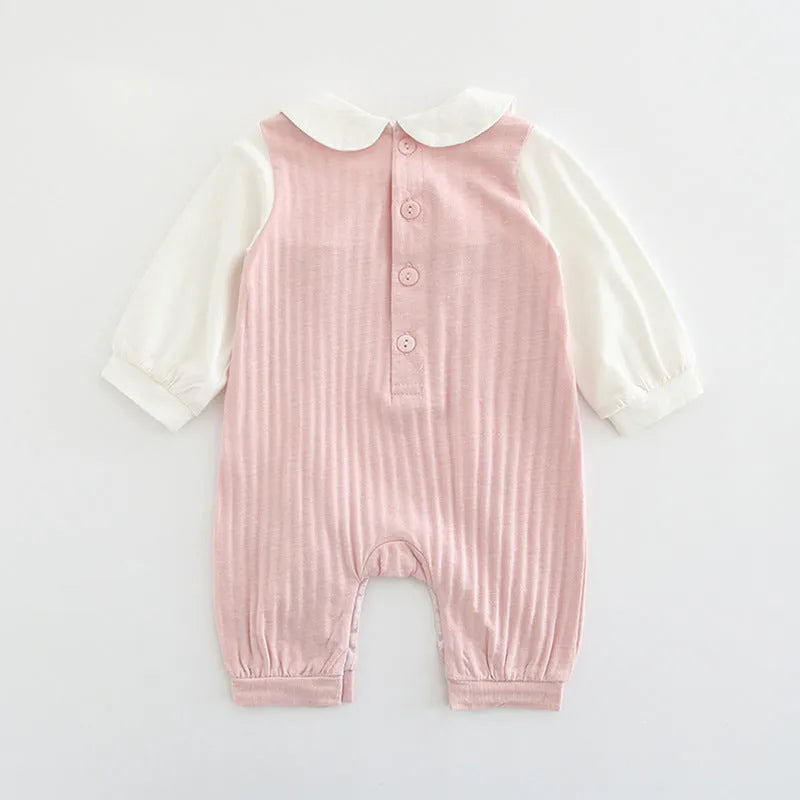 Pink baby girl's embroidered long sleeve cotton jumpsuit on a hanger