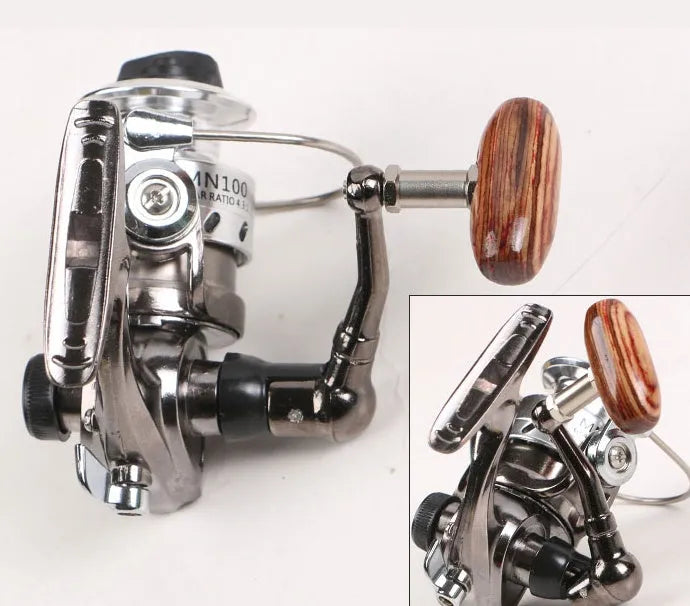 Mini 100 all metal fishing reel in black, 8cm high, with wooden handle rocker arm folded