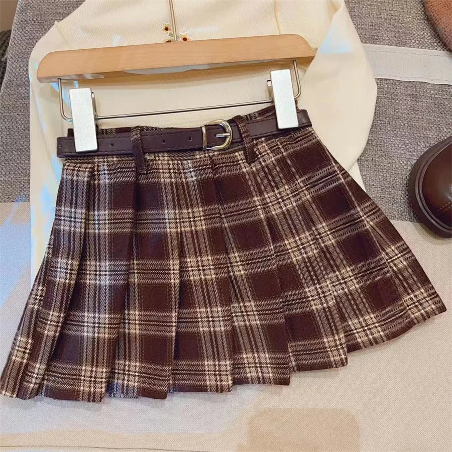 Girls red and black plaid pleated A-line skirt on a hanger.