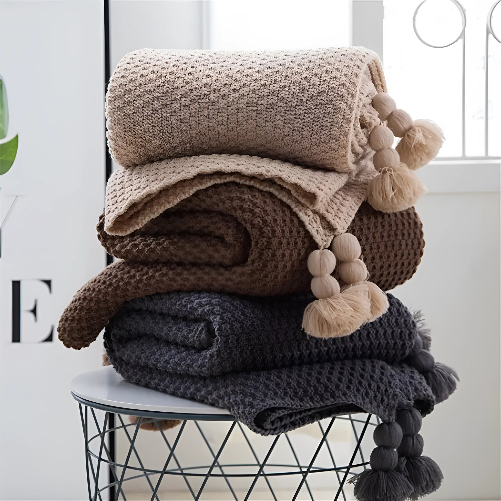 Nordic-style fringed knit ball acrylic blanket in beige colour, laid flat showing its 130x170cm size.
