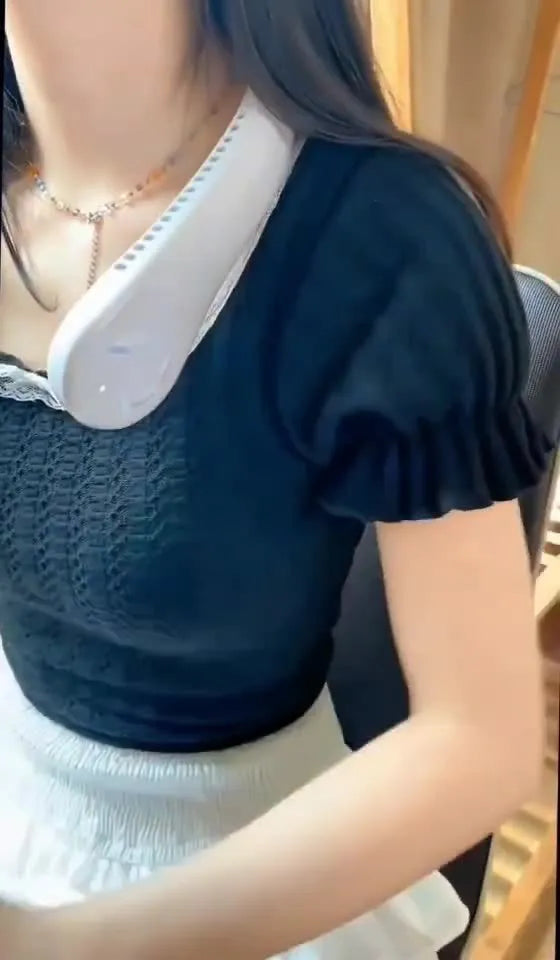 Pink bladeless neck fan worn around neck with USB charging cable