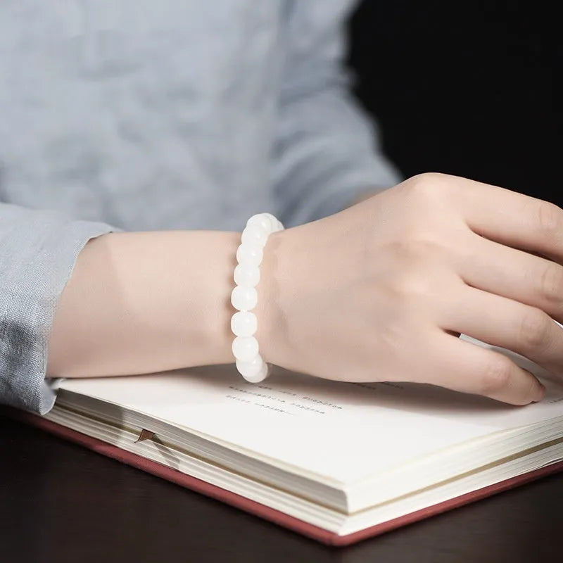 White Hetian jade barrel bead bracelet on wrist, showing unisex design and elasticated band.